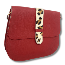 Red handbag with a leopard print strap on a white background