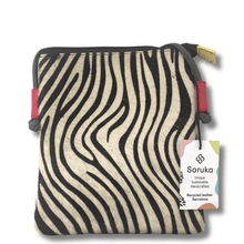 Zebra-patterned pouch with red accents and a visible brand tag on a white background