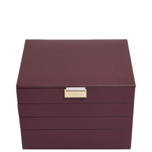 A rectangular leather jewelry box in deep burgundy with a textured finish and a small gold-tone metal plaque on the front, photographed against a solid white background.