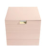A light pink leather jewelry box with a gold-tone metal clasp on the front, set against a plain white background.