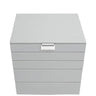 A light gray jewelry box with a hinged lid and four drawers, featuring a small silver metal brand plaque on the front.