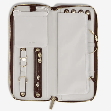 Open wallet with leather straps and floral embellishments on a white background