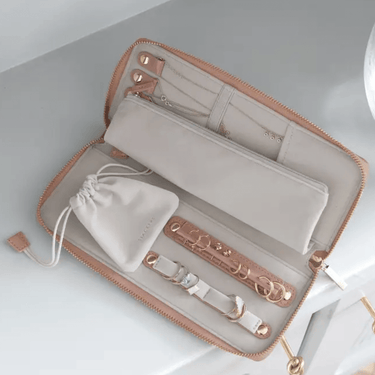 Open jewelry organizer with jewelry items on a light gray background