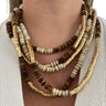 Necklace with brown, gold, and white beads on a person wearing a light-colored sweater.