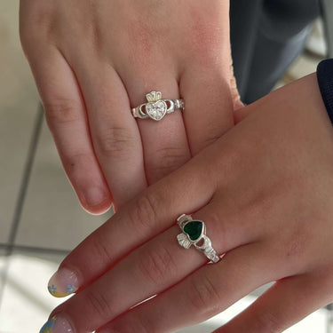 Two hands with rings on a blurred background