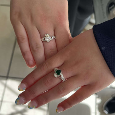 Two hands with rings on a blurred background