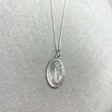 Silver necklace with a pendant on a light gray background