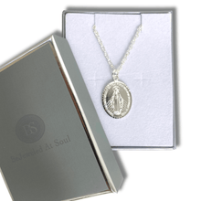 Silver necklace with pendant in a branded box on a white background