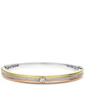 A two-tone bangle bracelet featuring a polished gold band, a rose gold band, and a channel-set row of clear stones. A round-cut clear stone is set in the center, with the bracelet photographed on a clean white background.