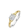 A two-tone diamond engagement ring with a yellow gold and silver-colored band, featuring a round-cut clear center stone in a prong setting, shown on a plain white background.