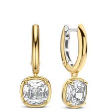 A pair of gold huggie hoop earrings with cushion-cut clear gemstones, shown from front and side angles on a white background.