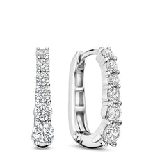 A pair of silver huggie hoop earrings with a row of clear round-cut gemstones, shown from front and side angles on a white background.