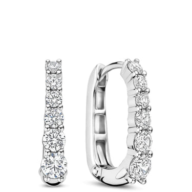 A pair of silver huggie hoop earrings with a row of clear round-cut gemstones, shown from front and side angles on a white background.