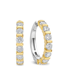 A pair of gold and silver huggie hoop earrings with round-cut clear gemstones, shown on a plain white background.