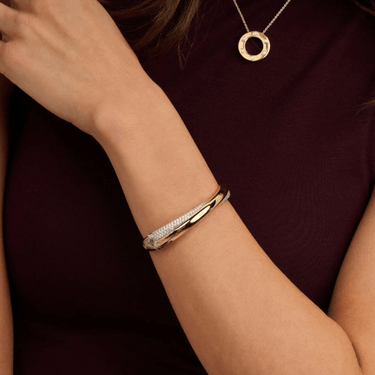 Gold bracelet on a wrist with a blurred background