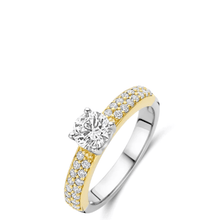 Two-tone gold and silver ring with a diamond on a white background