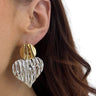 Gold and silver earrings worn by a person with dark hair.