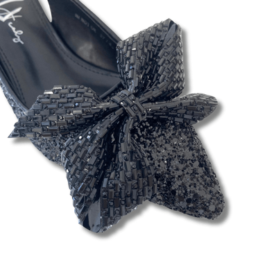 Black glittery bow on a shoe with a white background