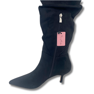 Black knee-high boot with a pink tag on a white background