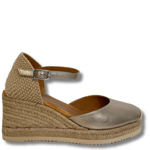 Gold wedge sandal with espadrille sole on a white background