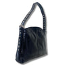 A patent black leather shoulder bag with a wide strap adorned with silver-tone metal studs, shown against a plain white background.