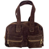 A dark brown suede handbag with two top handles, a top zipper closure, and two front zippered pockets with gold-tone hardware, shown against a plain white background.