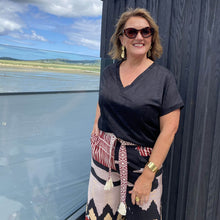 Woman standing outdoors with a scenic view of water and sky in the background