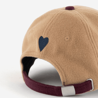 Beige cap with a blue heart on the back against a white background