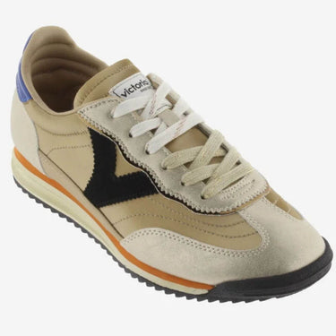Beige sneaker with black and orange accents on a white background
