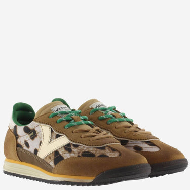 Brown sneakers with green laces and leopard print details on a white background