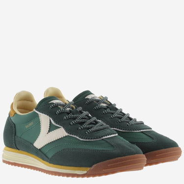 Green sneakers with brown soles on a white background