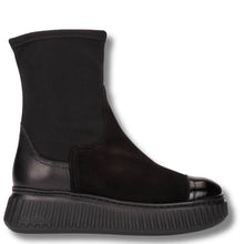 A black ankle boot with a textured leather cap toe, elastic side gore, and a chunky ridged platform sole, shown from a side profile on a white background.