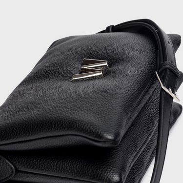 Black leather bag with a brand logo on a light gray background