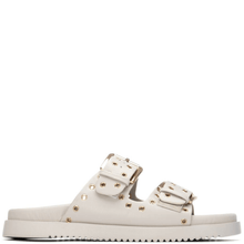 White sandal with gold buckles on a white background