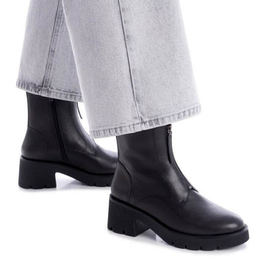 Black ankle boots worn with light gray jeans on a white background