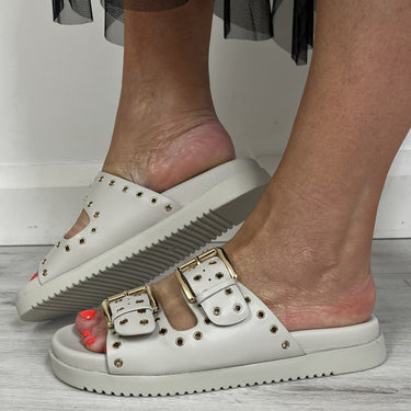 beige flat sandals with double straps and gold studs