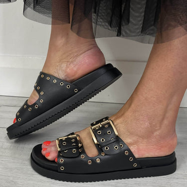 flat black sandals with black straps and gold buckles