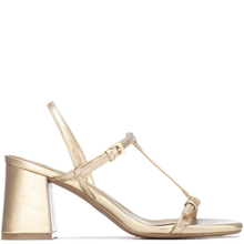 Gold high-heeled shoe with a clear heel on a white background