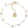 Gold bracelet with beads and a square charm on a white background