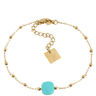 Gold bracelet with a turquoise bead on a white background